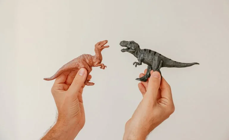 hands holding miniature dinosaurs