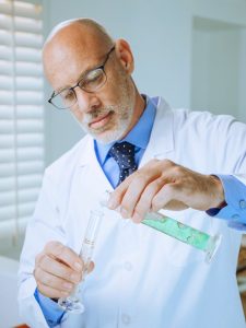 a man in white coat doing an experiment