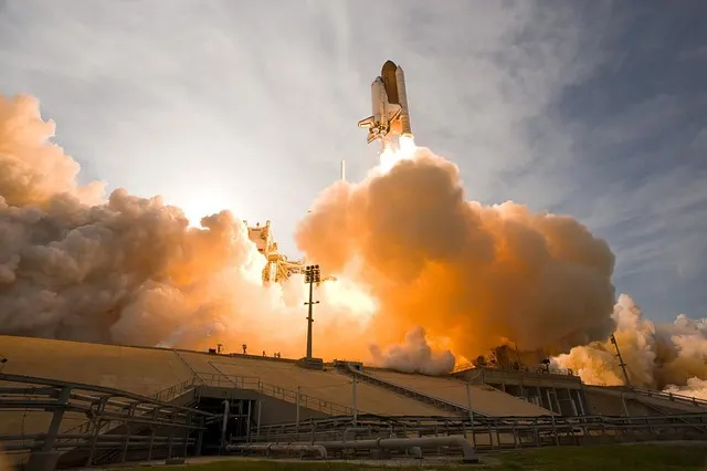 The Space Shuttle lifting off from its launch pad in a cloud of exhaust