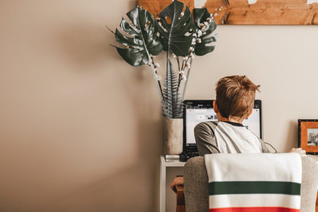 a boy studying online using laptop