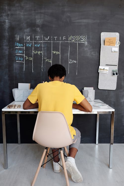 Free Boy in Yellow Crew Neck T-shirt Sitting on Chair Stock Photo