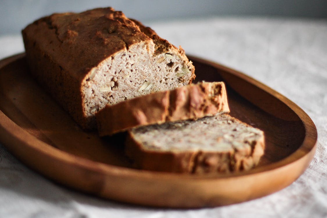 Free Close-Up Photo of  Sliced Bread on Oval Wooden Plate Stock Photo