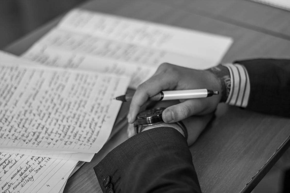 Free Grayscale Photography of Person Holding Pen Stock Photo