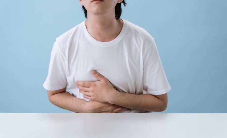 Free Man in White Shirt Suffering from a Stomach Pain Stock Photo