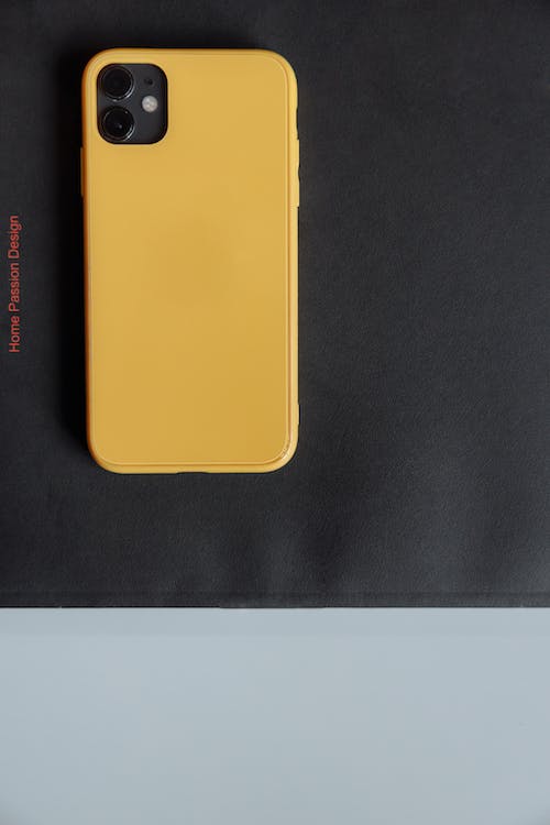 Free Overhead Shot of a Phone with a Yellow Case Stock Photo