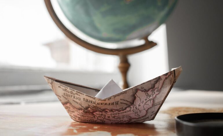 Free Paper boat near globe in room Stock Photo