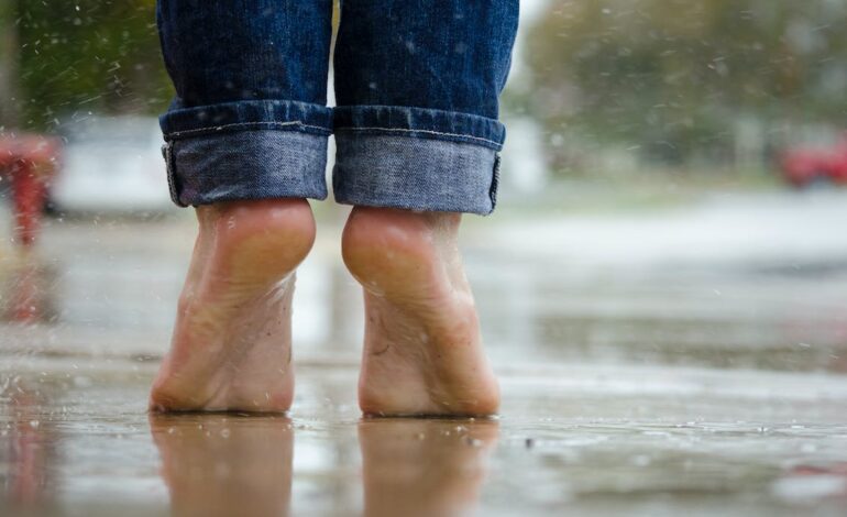 Free Person in Blue Denim Jeans Standing Outside the Rain Stock Photo