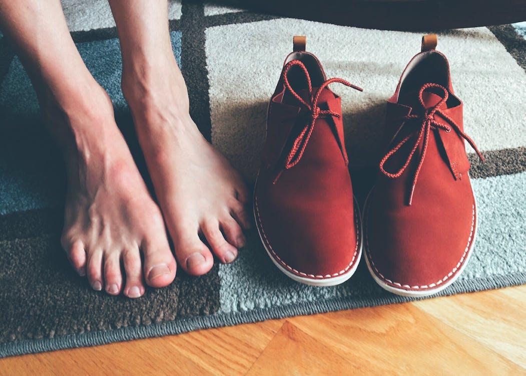 Free Person's Feet Beside Brown Shoes Stock Photo