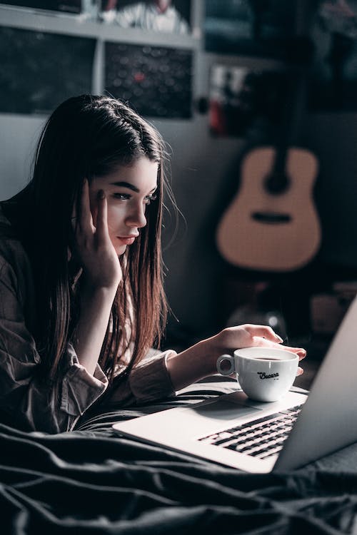 Free Photo of Woman Lying on Bed While Using Laptop Stock Photo