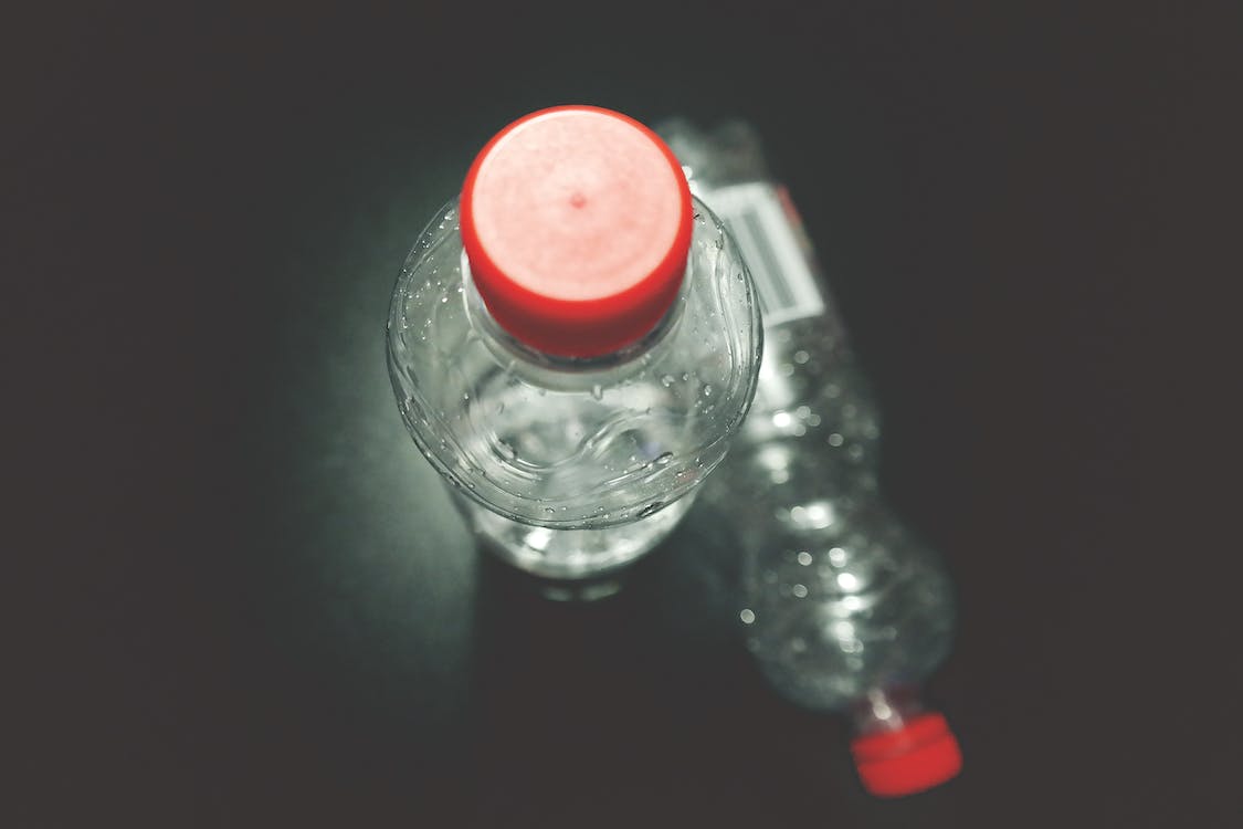 Free Two Clear Plastic Bottles on Black Surface Stock Photo