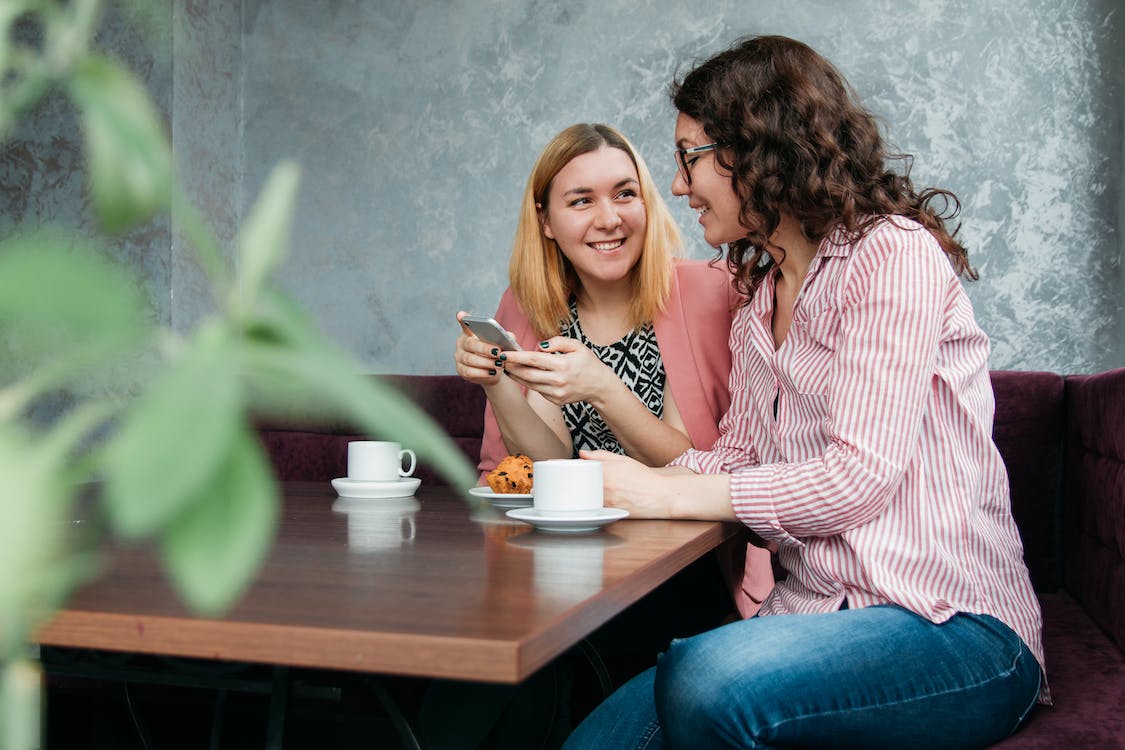 Free Two Women Dining on Brown Wooden Table Stock Photo