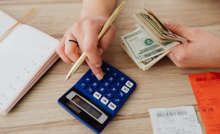 Free Woman Calculating Money and Receipts Using a Calculator Stock Photo