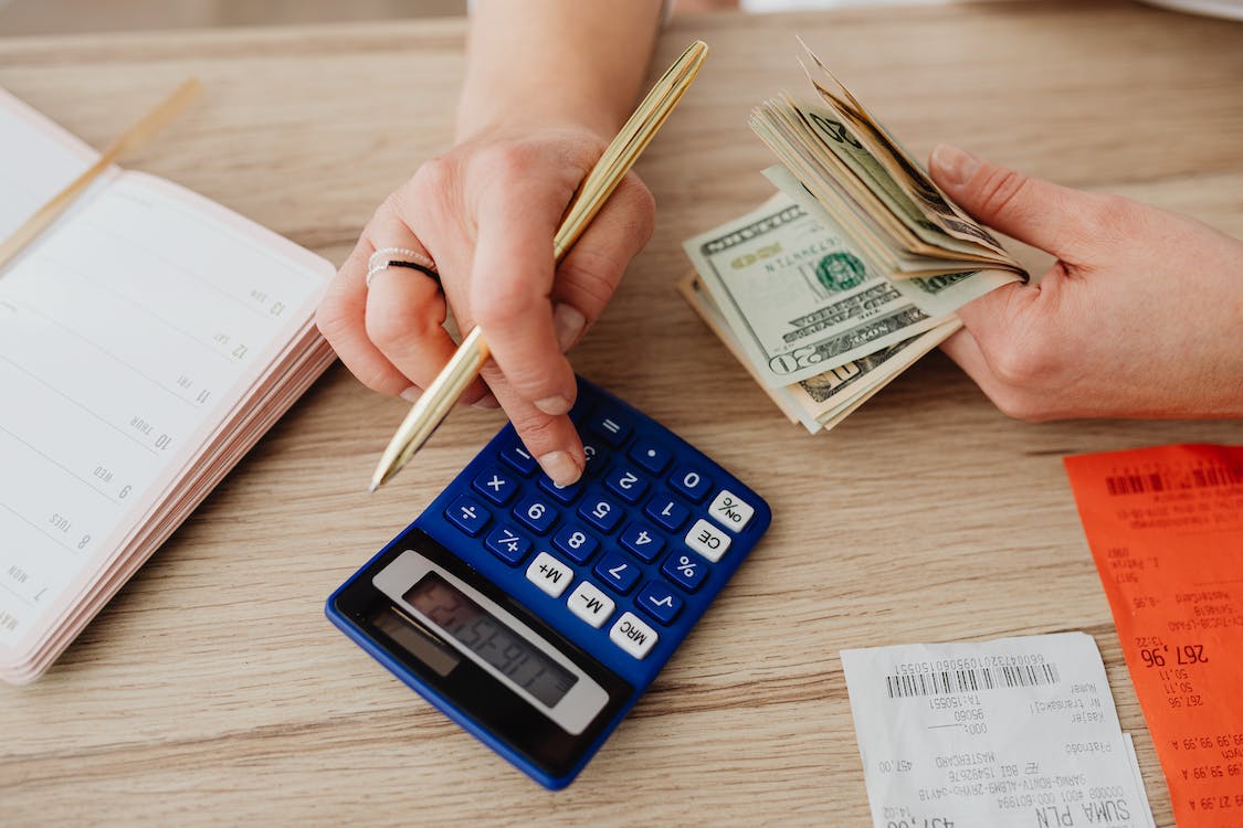 Free Woman Calculating Money and Receipts Using a Calculator Stock Photo