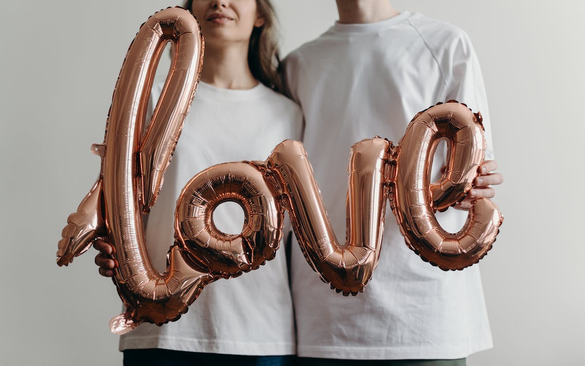 Free Woman in White Crew Neck Shirt With Brown and White Heart Shaped Beaded Necklace Stock Photo