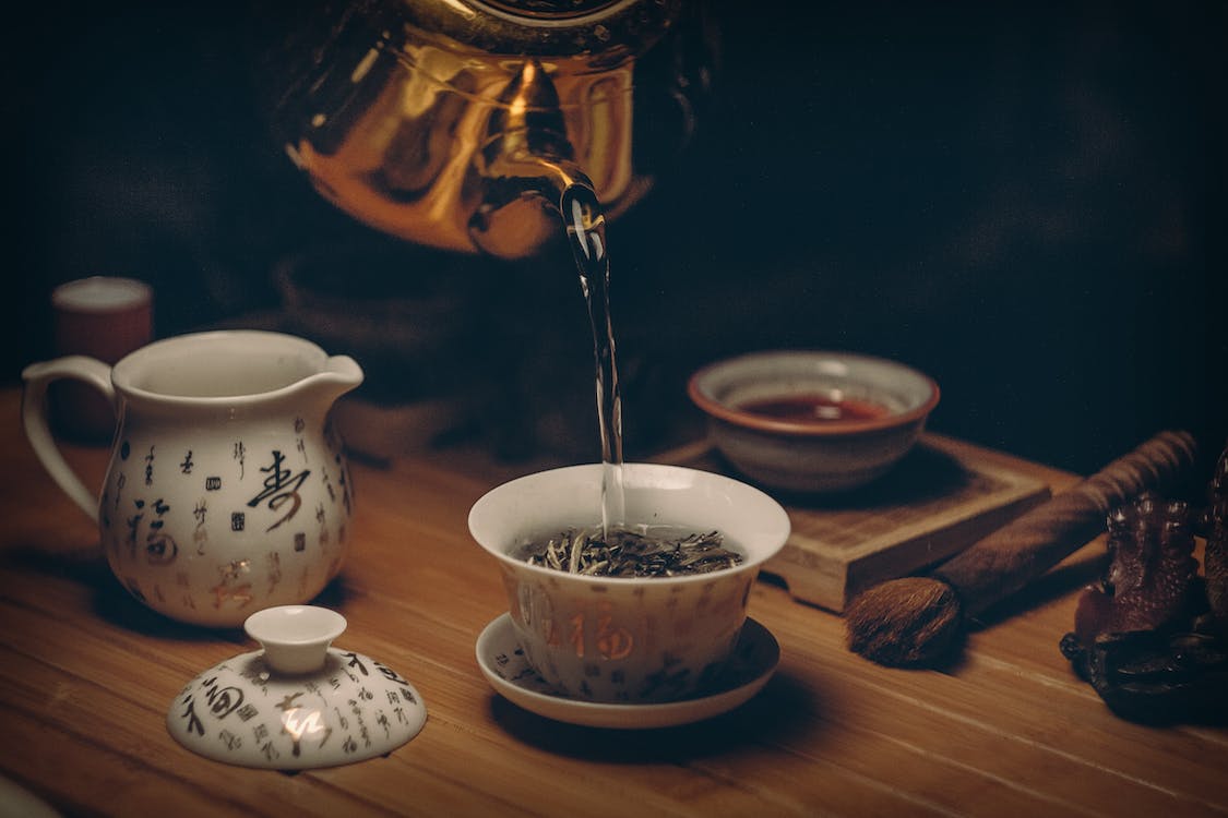 Free Gold Kettle Pouring Hot Water on Cup of Tea Stock Photo