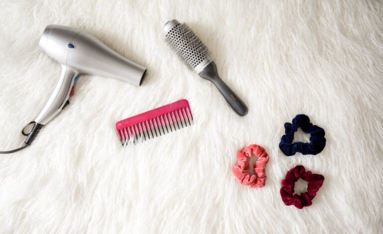 Free Grey Hair Blower Near Pink Hair Combs and Scrunchies Stock Photo