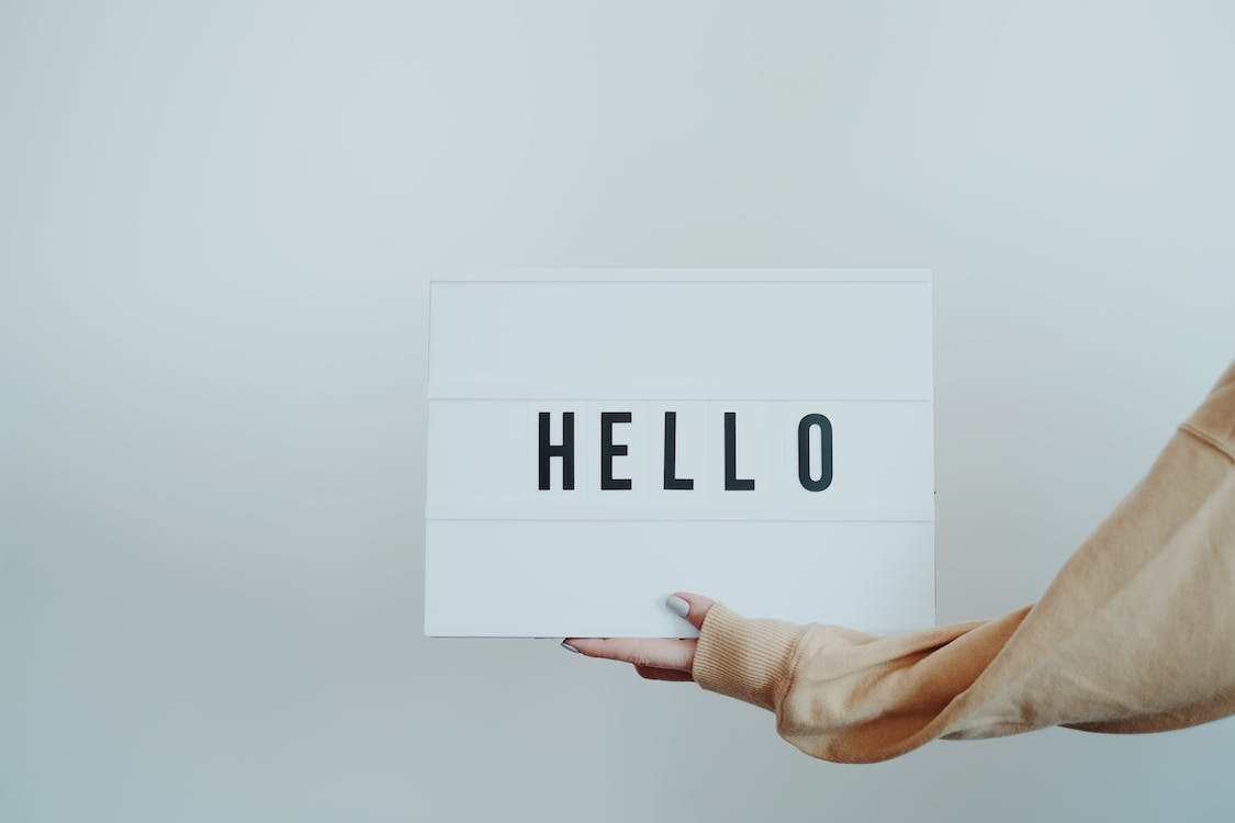 Free Person Holding a Hello Sign Stock Photo