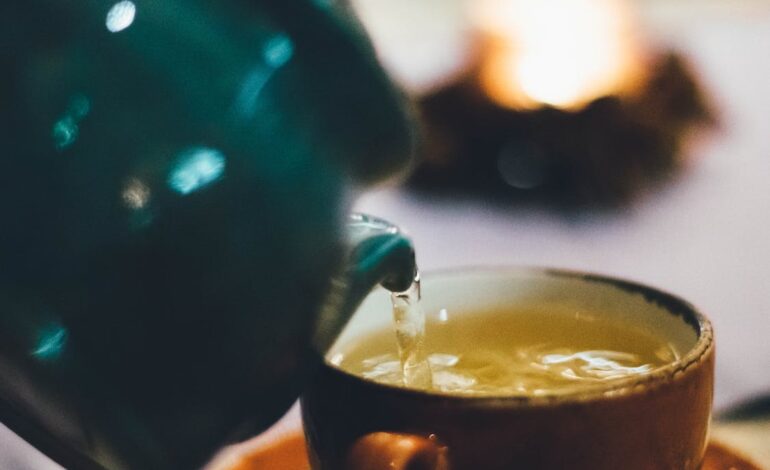 Free Person Pouring Liquid Into Brown Ceramic Cup Stock Photo