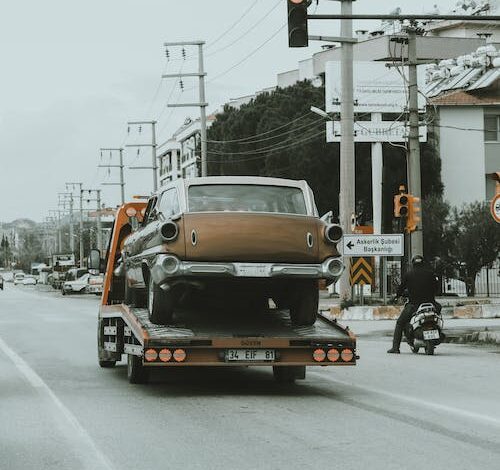 Free Truck Towing Vintage Car through Streets Stock Photo