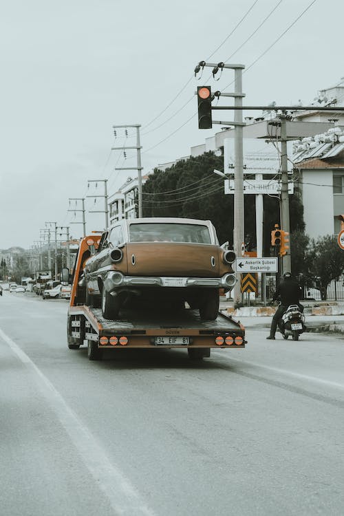 Free Truck Towing Vintage Car through Streets Stock Photo