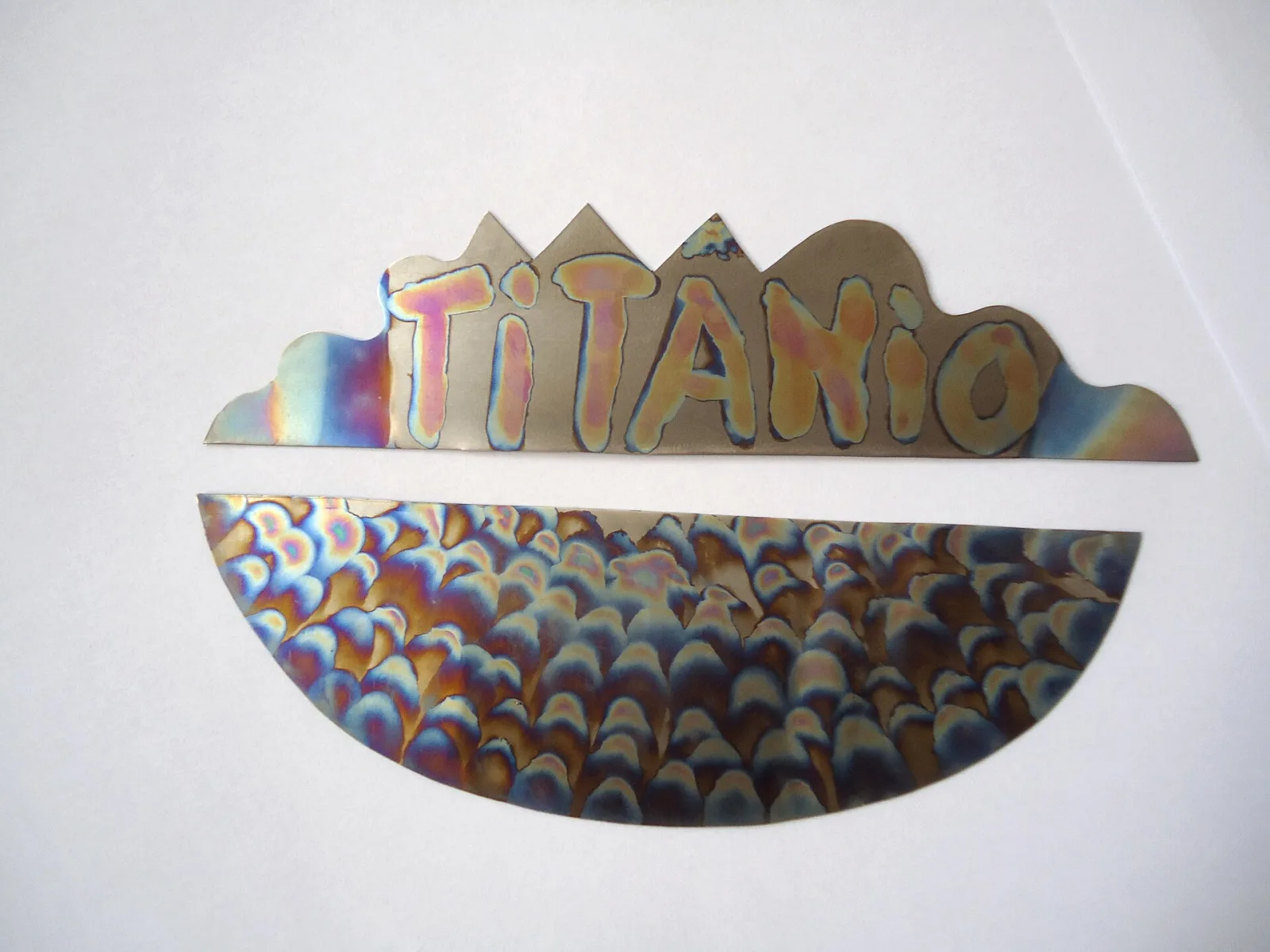 Thin titanium sheets showing rainbow colours of blue, gold and purple from anodising