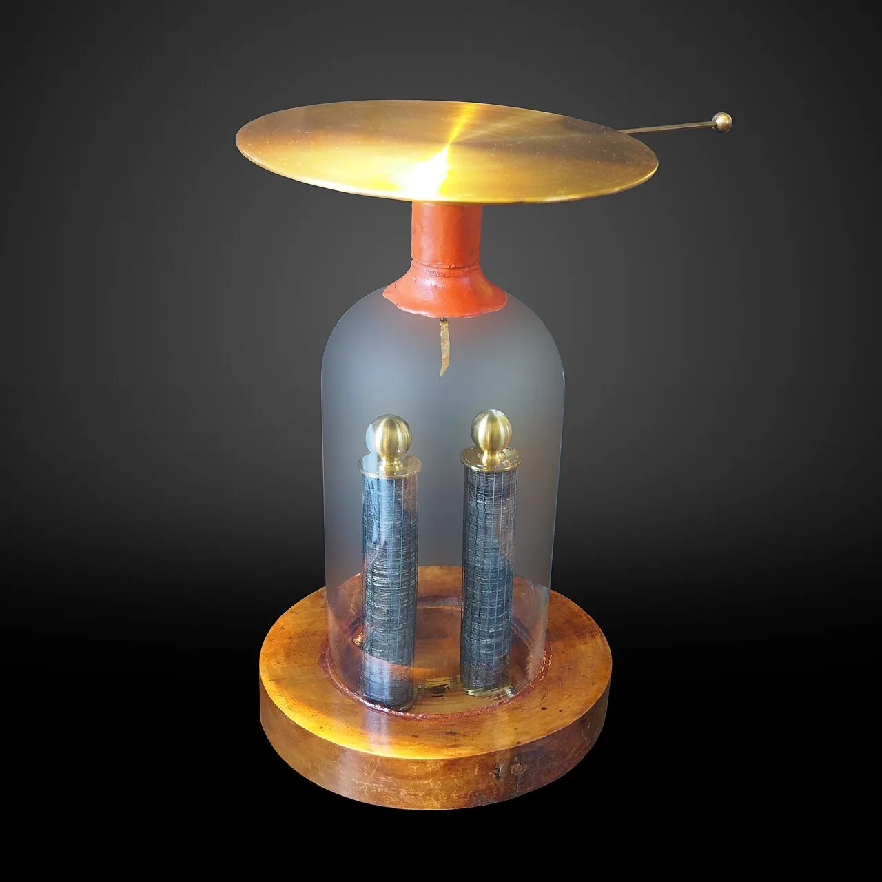 Antique electroscope with a brass disc on top of a glass bell jar on a wooden base