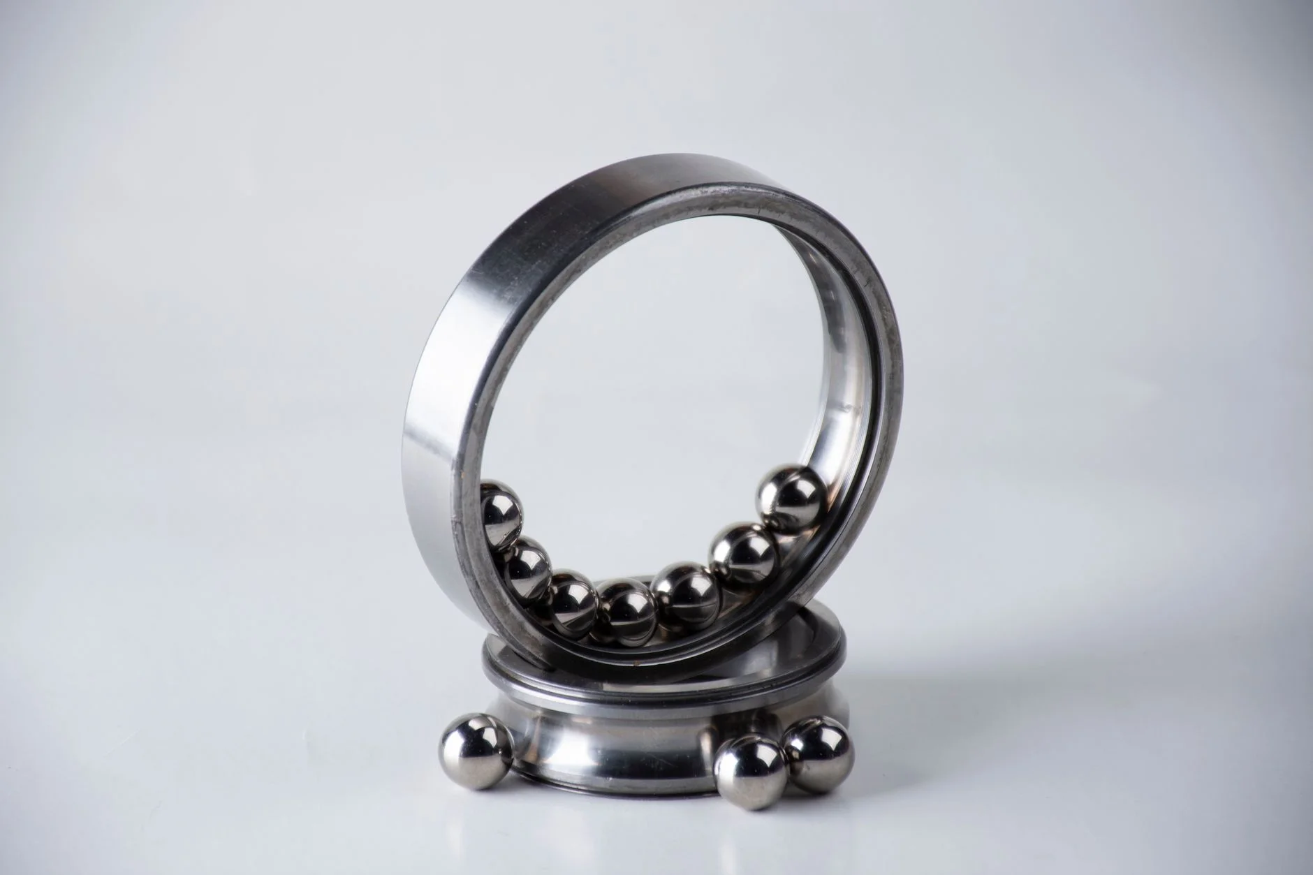 A ball bearing taken apart, with its steel balls and rings laid out