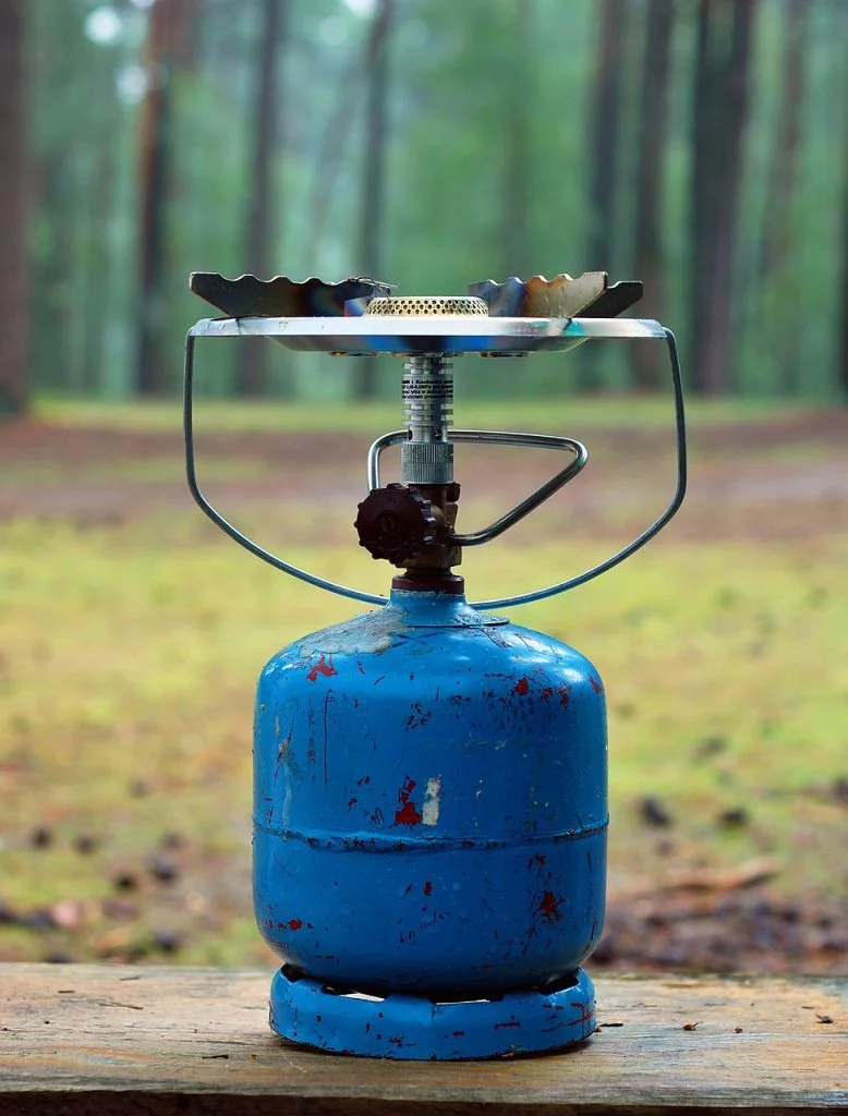 Small camping gas stove screwed onto a portable LPG cartridge