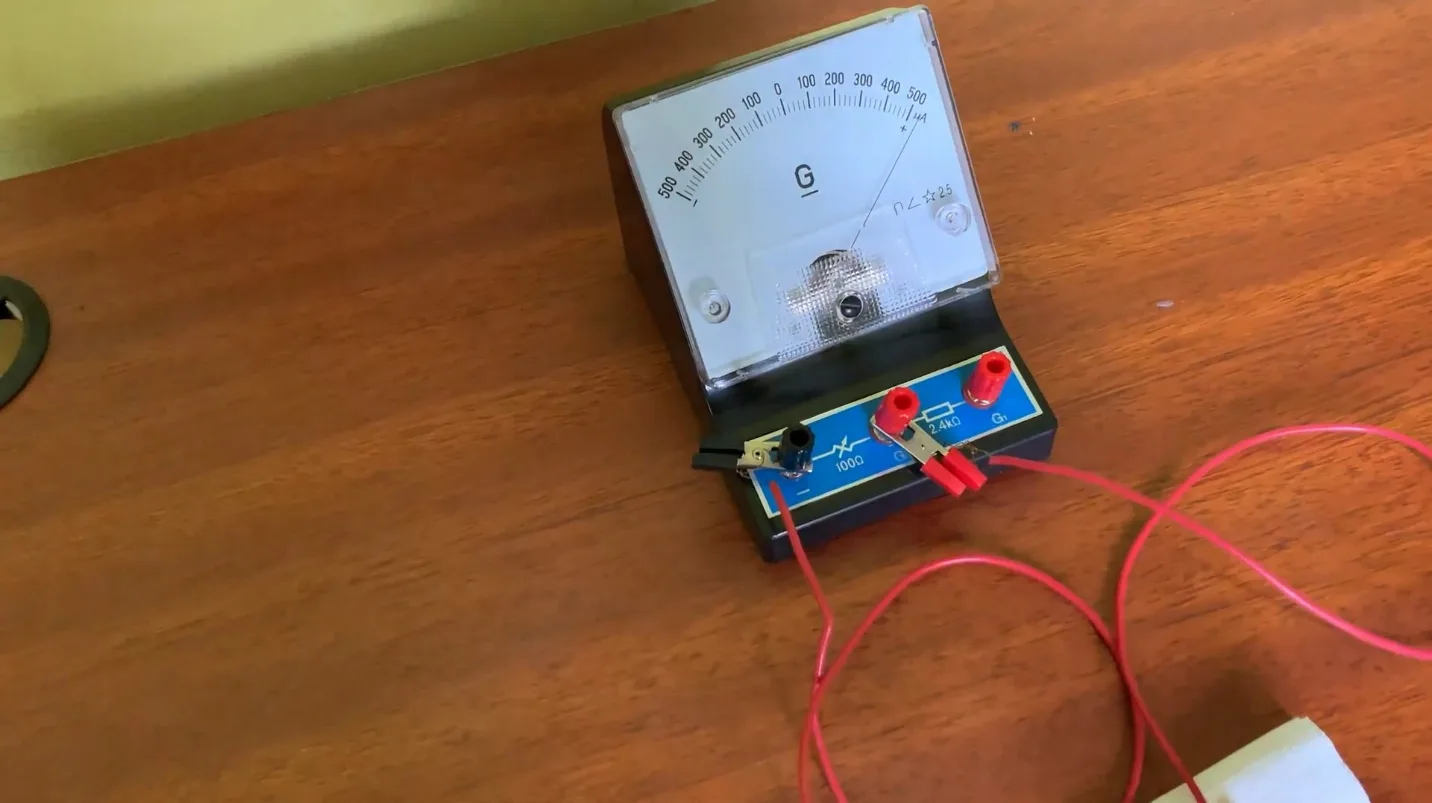 Close-up of the galvanometer connected to the lime cell, its needle swung over to the right-hand positive side of the microamp scale