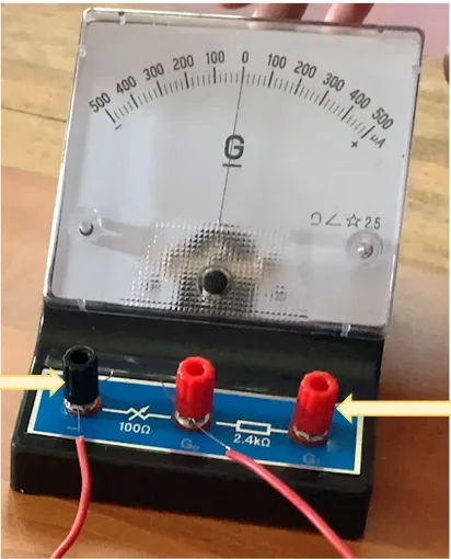 Centre-zero galvanometer with a 500–0–500 microamp scale, a black negative terminal and two red terminals, arrows pointing to the black negative terminal and the right-hand red terminal (G1)