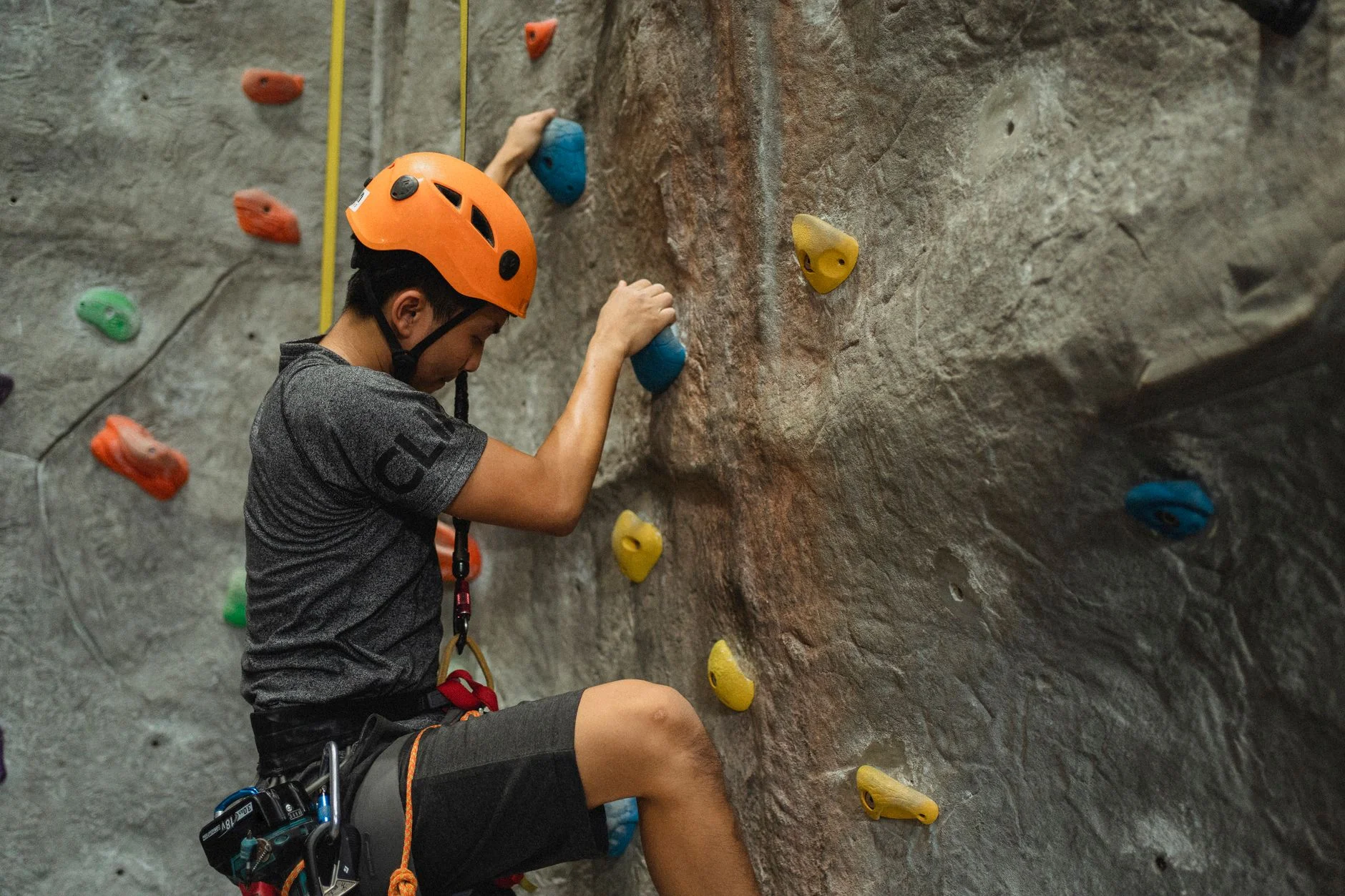 A climber working their way up an indoor climbing wall