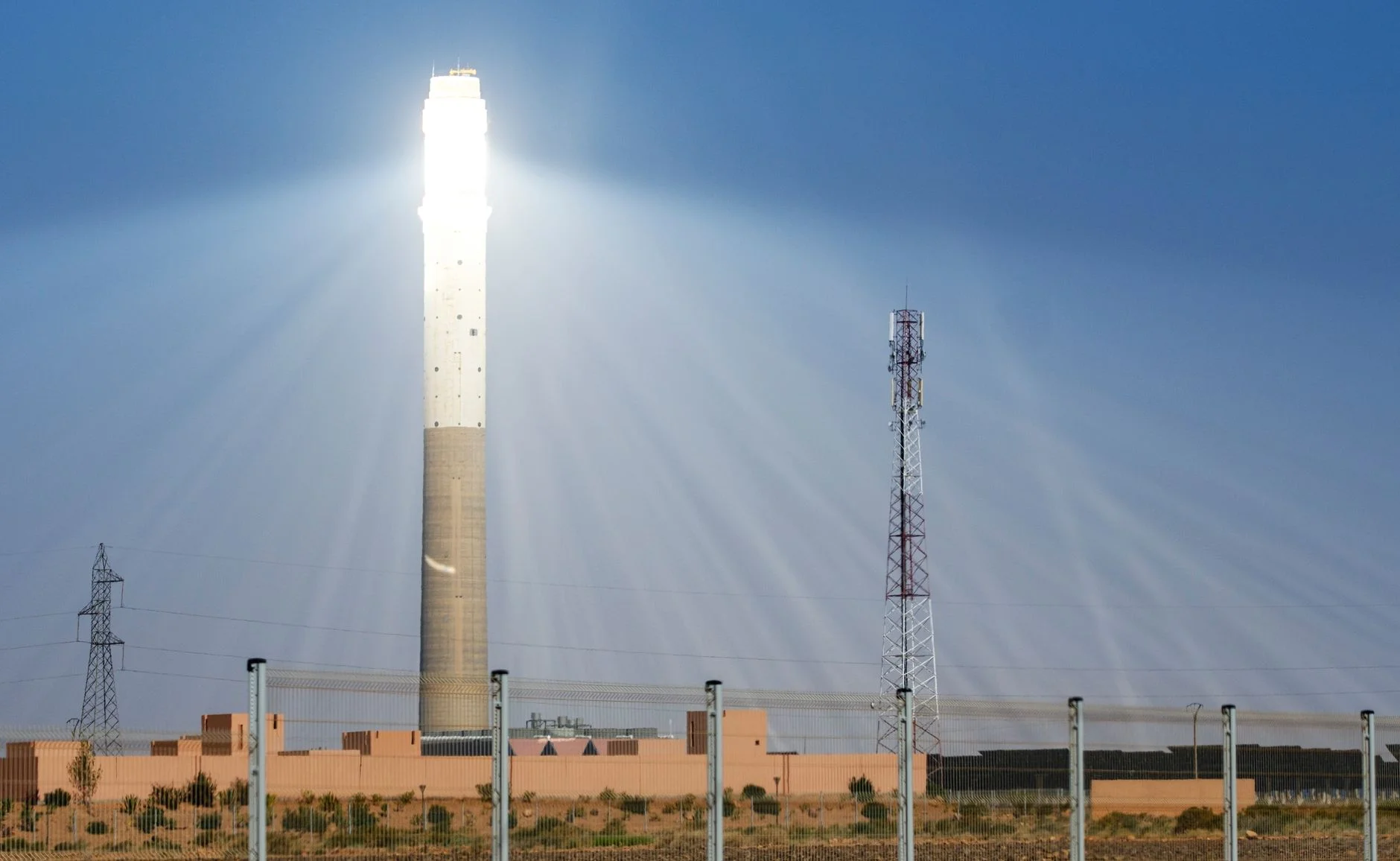 Concentrated solar power tower glowing with reflected sunlight in Morocco