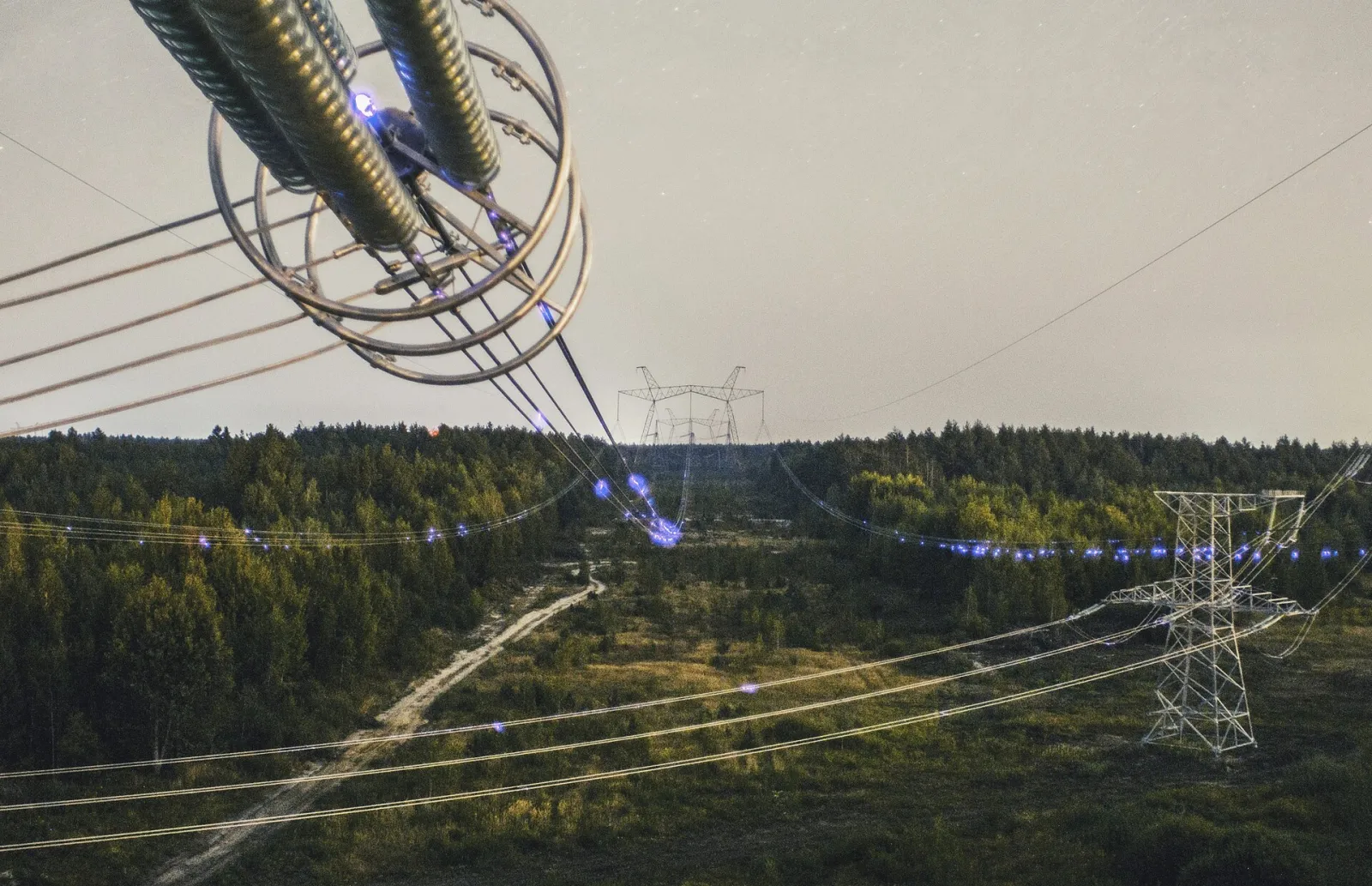 Blue corona discharge glowing on the conductors of a 750 kV power line crossing in Ukraine