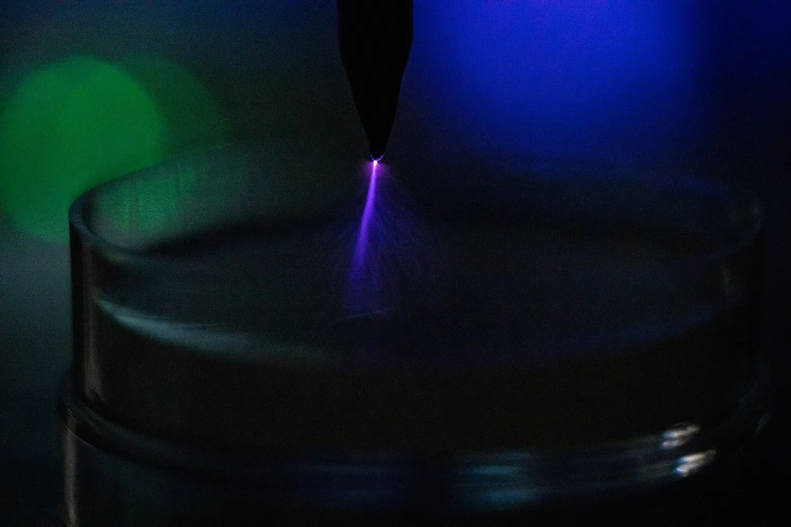 Violet corona discharge spraying from the tip of a sharp graphite electrode