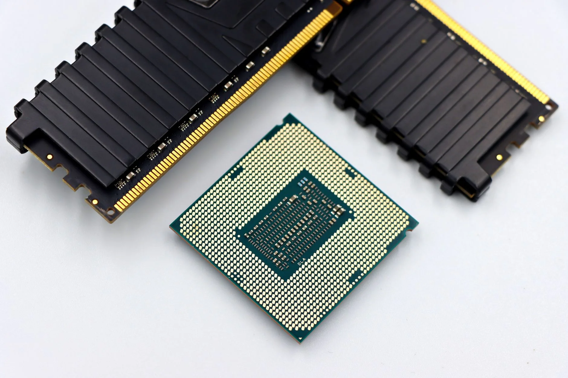 A processor chip next to two heat-spreader RAM modules