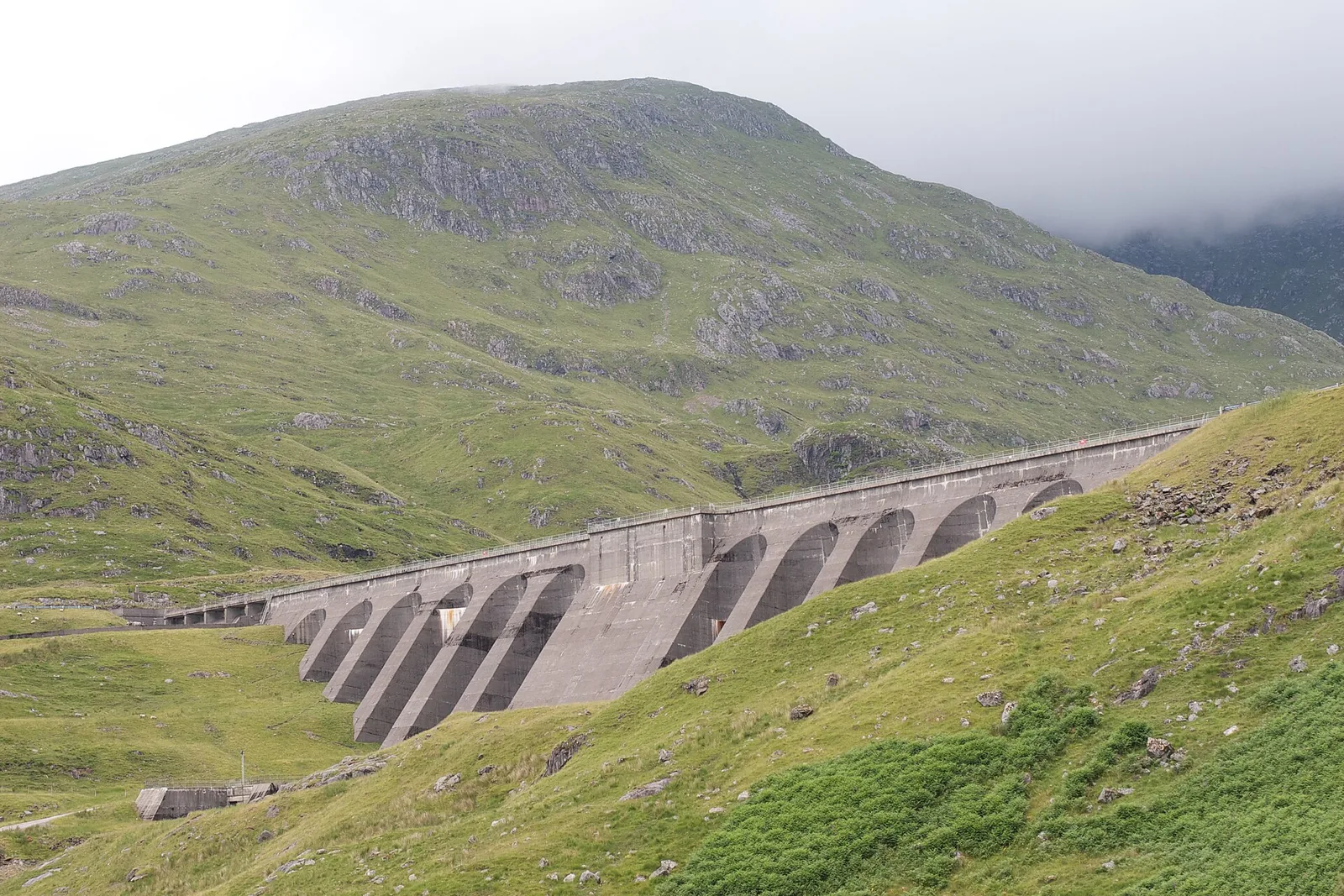 Cruachan Dam in Argyll, Scotland, a buttressed concrete dam curving across a green hillside
