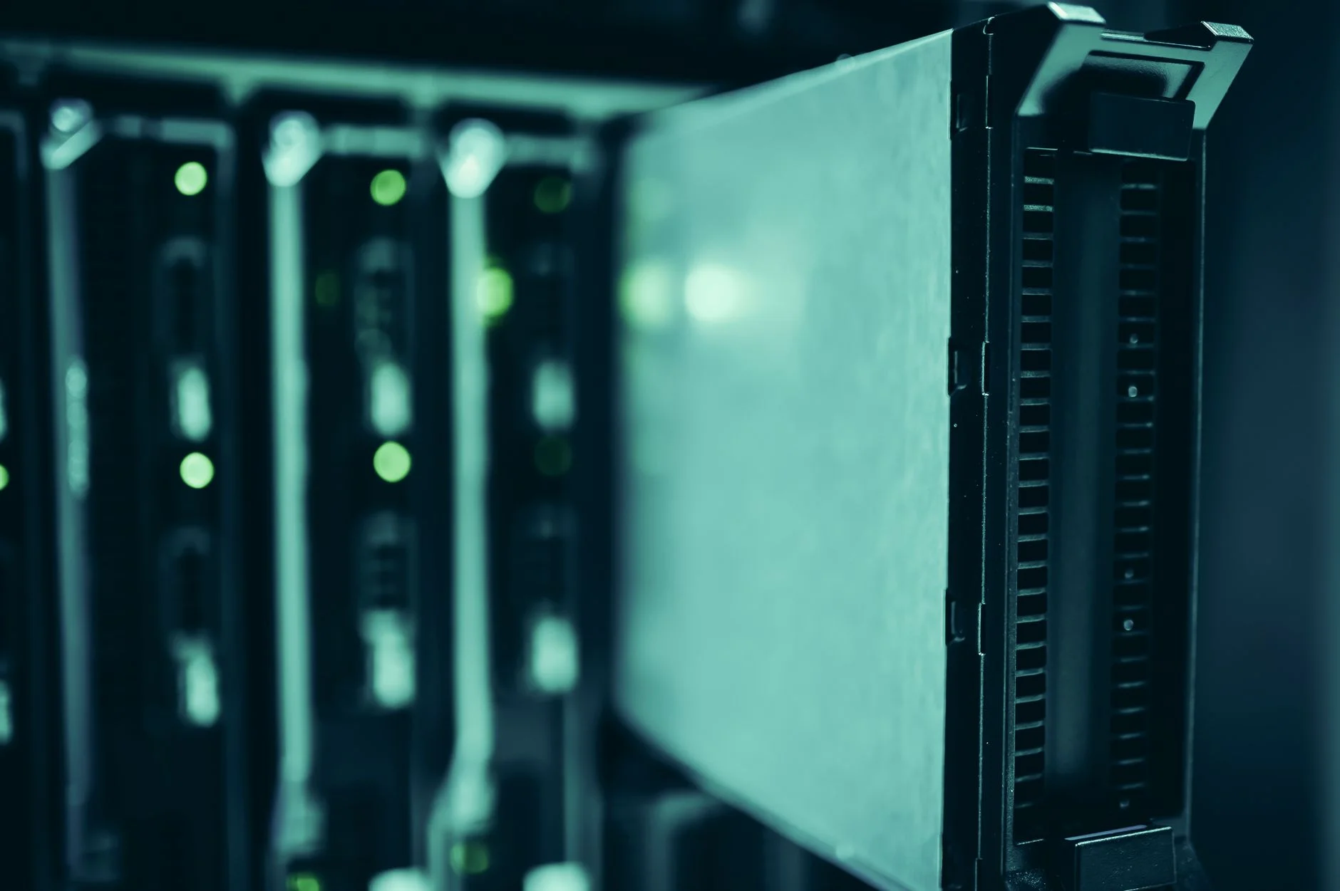Close-up of a server unit pulled partly out of a rack, with green status lights on the units beside it