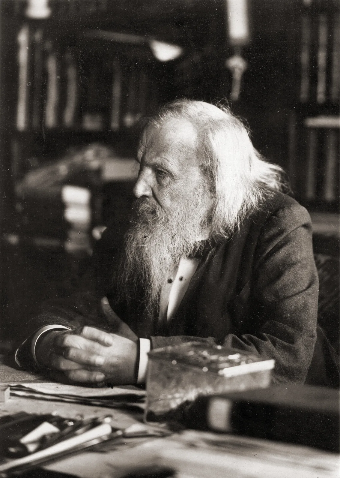 Dmitri Mendeleev seated at his desk in his study