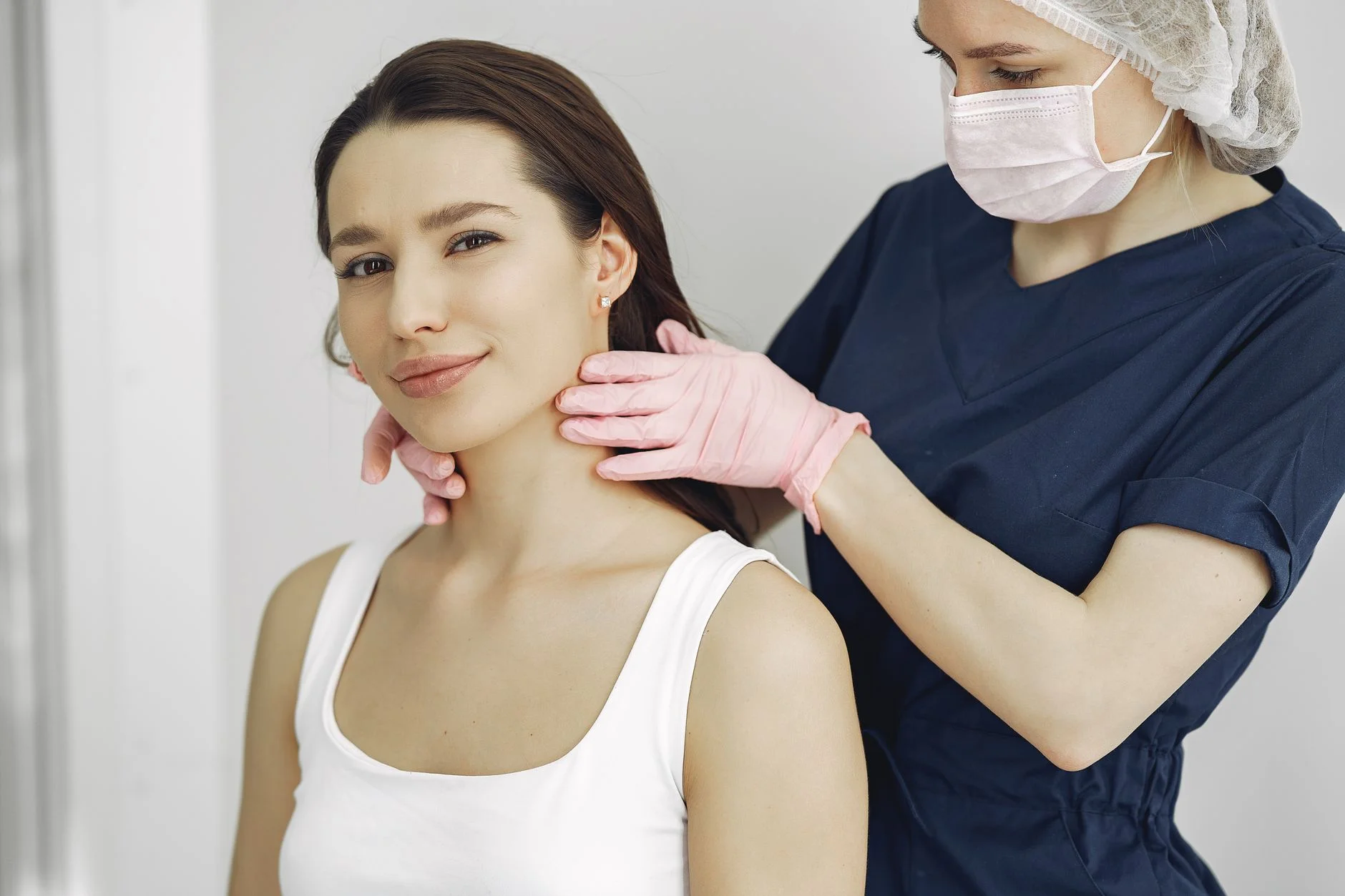 Doctor gently feeling the lymph nodes in a patient’s neck during an examination