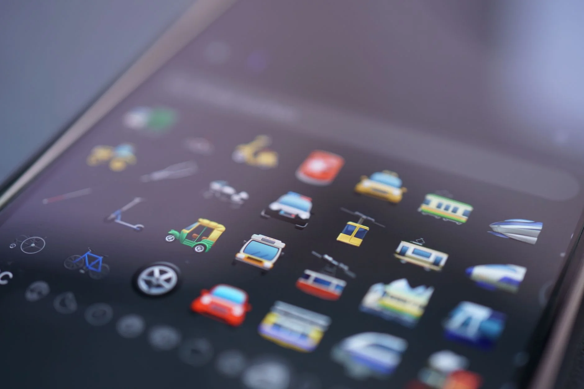 Close-up of transport emojis such as cars, trams and bicycles on a smartphone keyboard