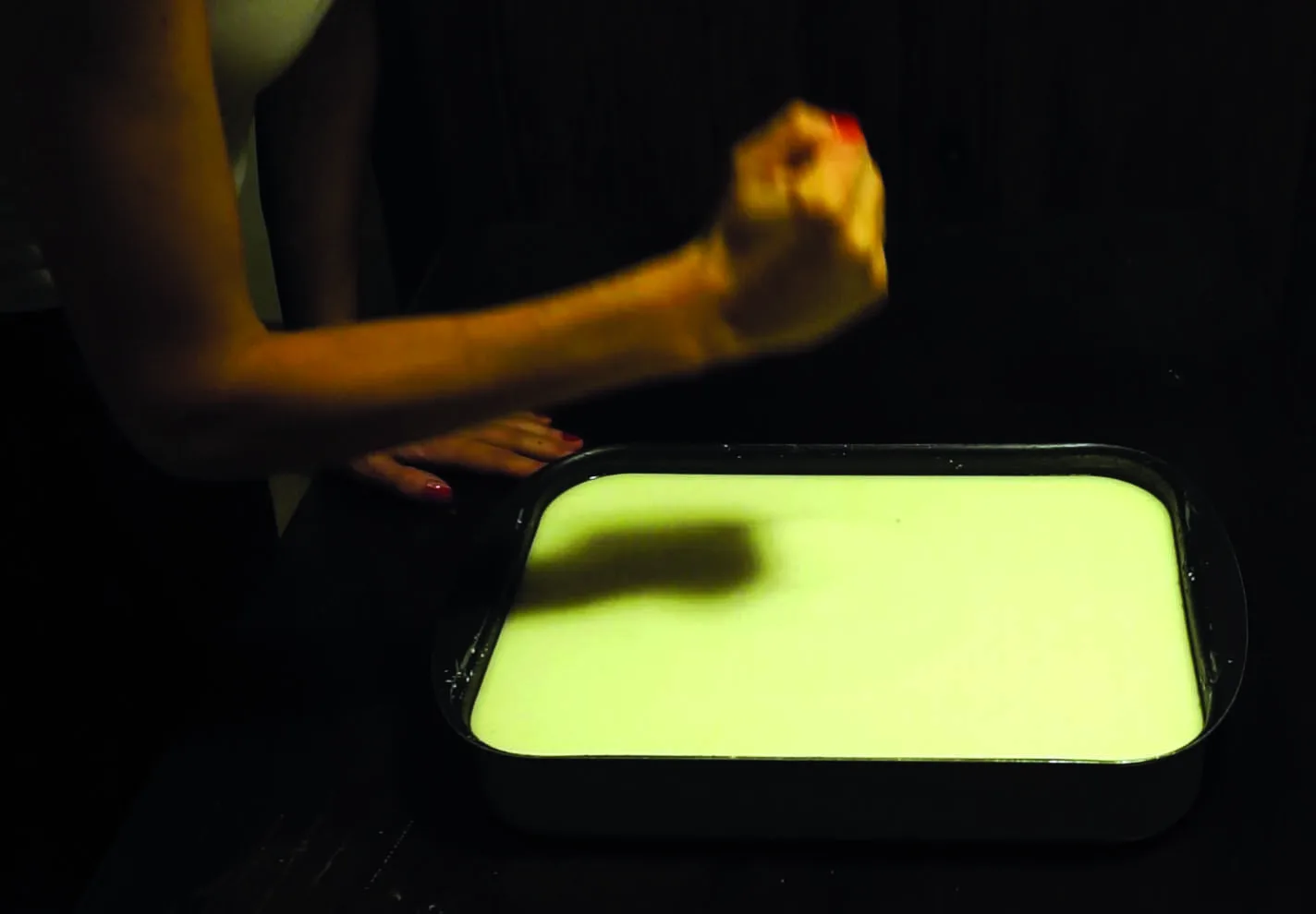 A fist about to punch a tray of cornflour and water mixture