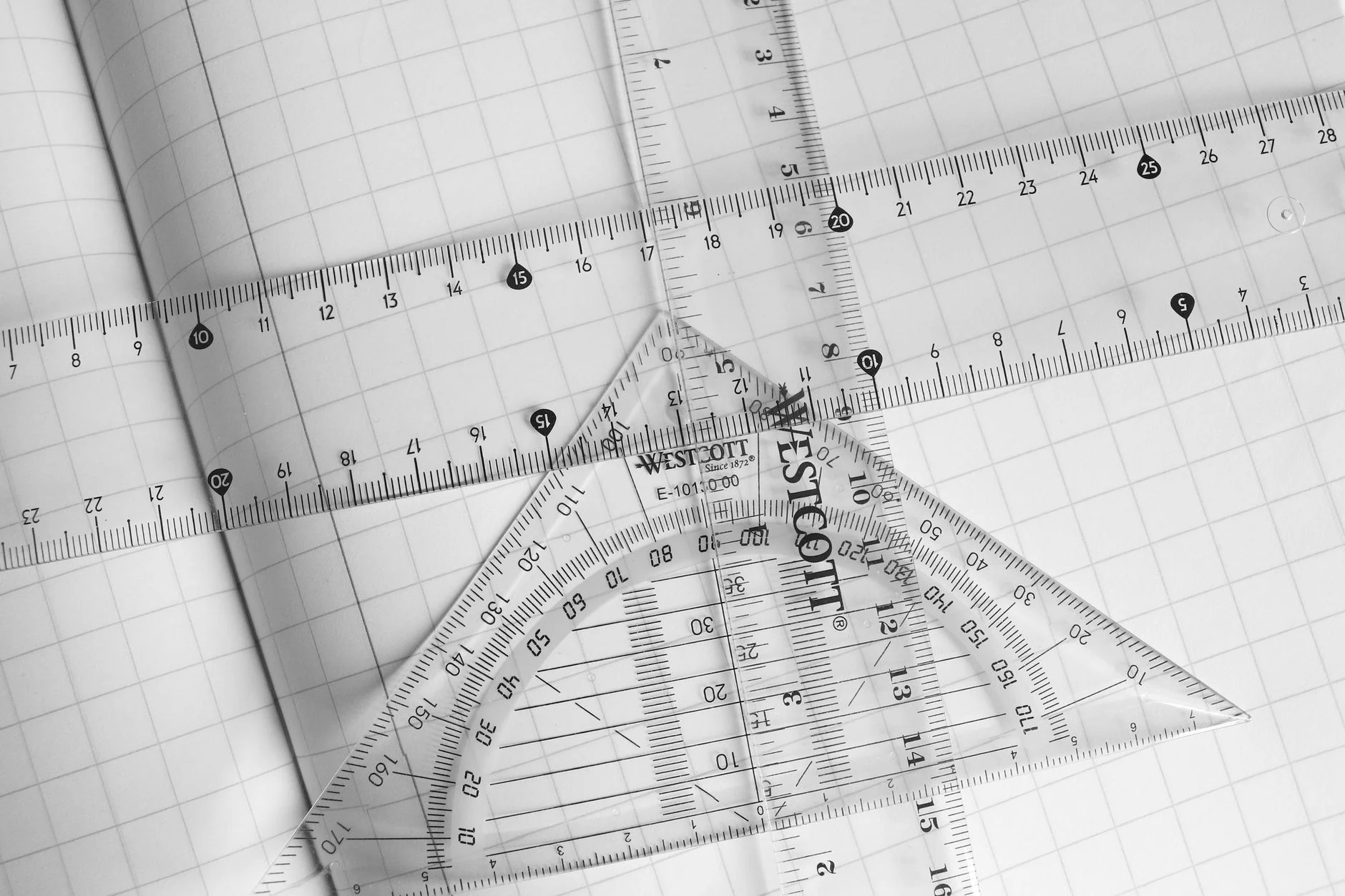 Transparent rulers and a protractor on squared paper