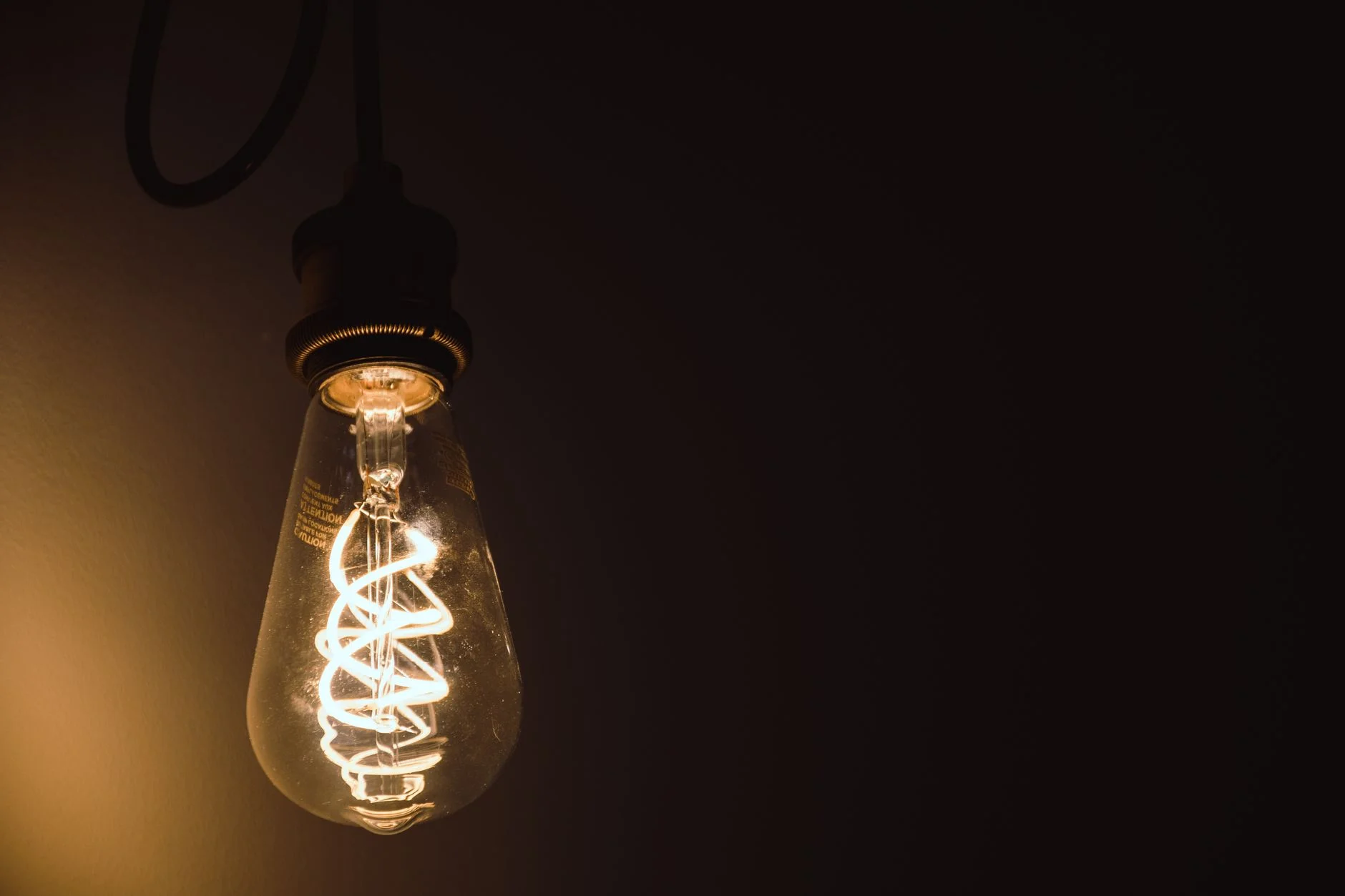 A glowing filament light bulb in close-up