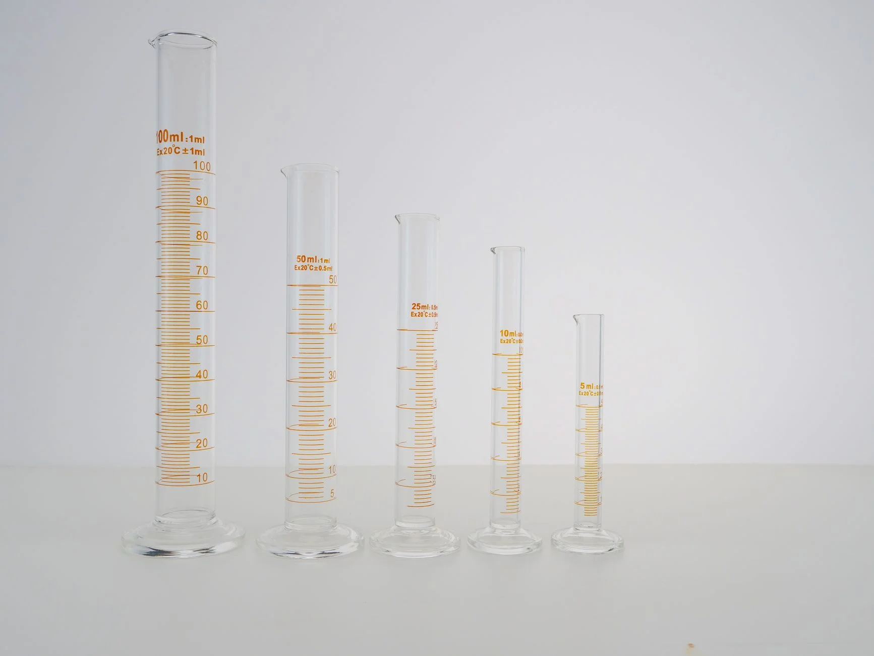 Five glass measuring cylinders of different sizes, from 5 ml to 100 ml, standing in a row