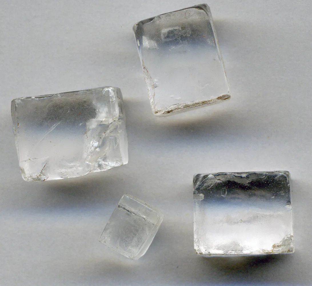 Four colourless cube-shaped halite crystals, the mineral form of sodium chloride