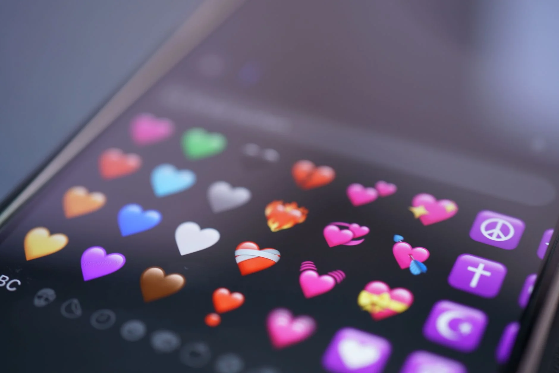 Close-up of coloured heart emojis on a smartphone emoji keyboard