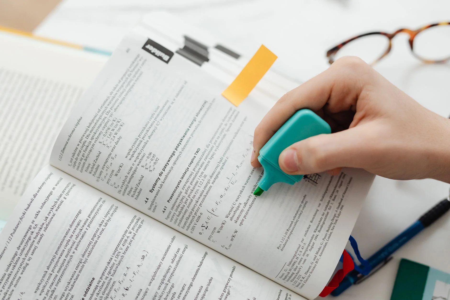A student highlighting key information in a textbook