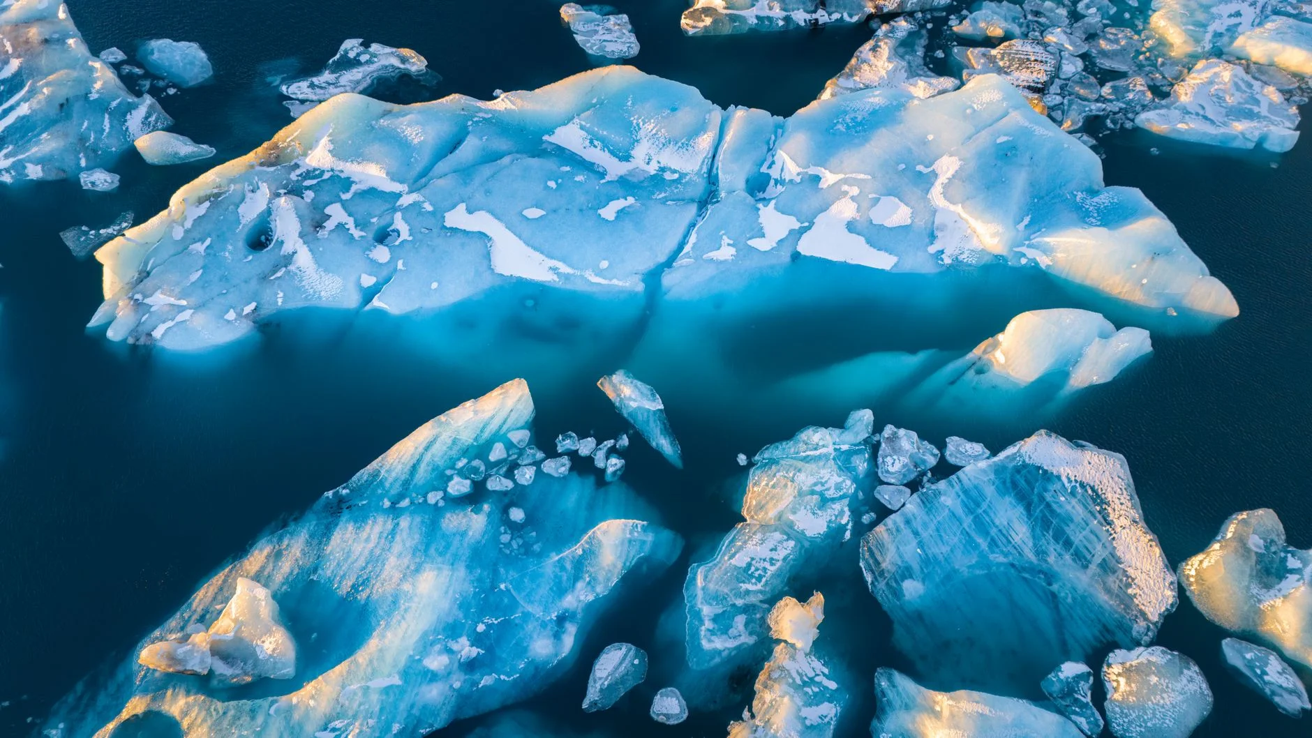 Aerial view of broken icebergs floating in deep blue water
