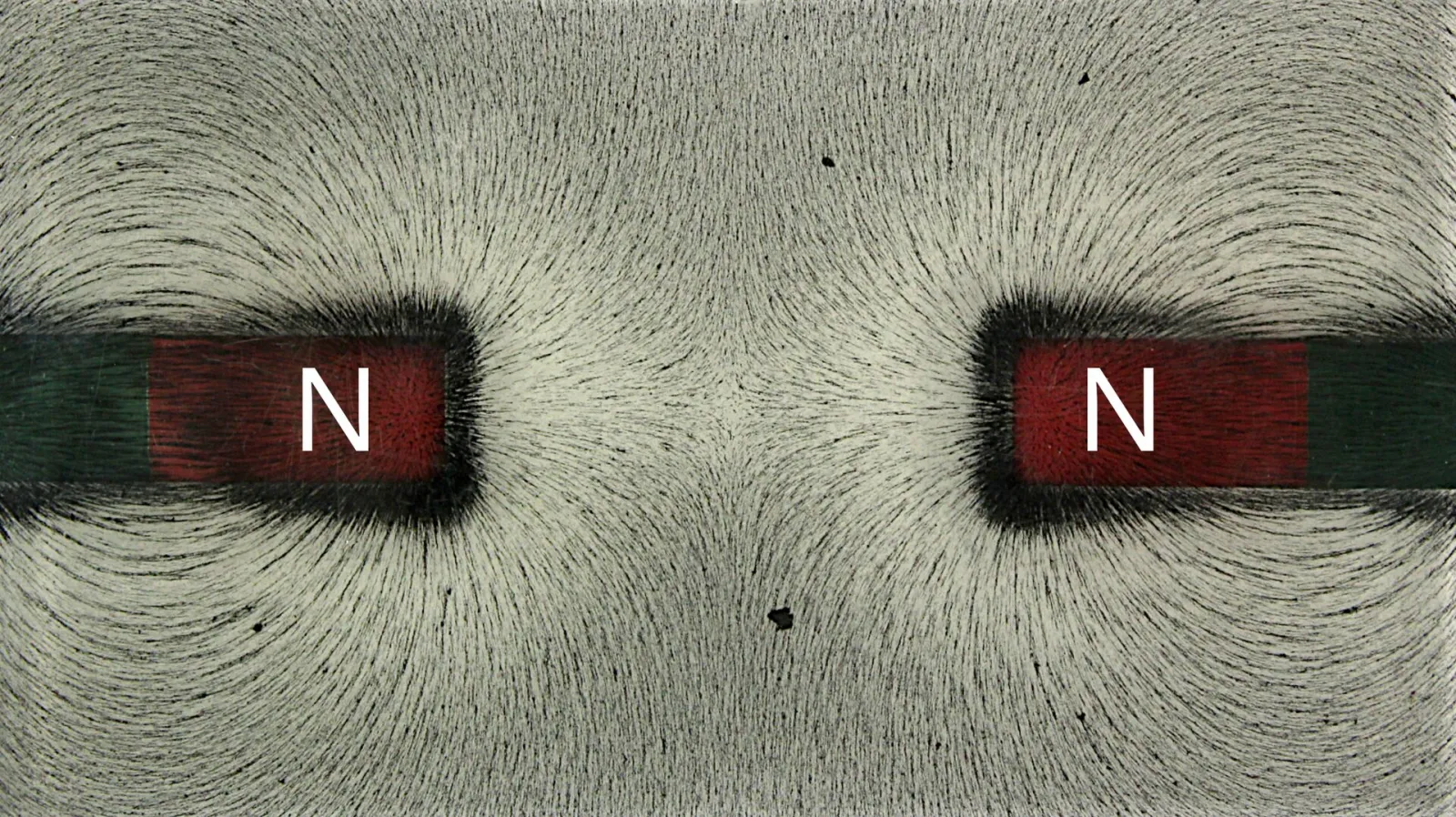 Iron filings bending away from the gap between two N poles facing each other, leaving an almost empty region in the middle