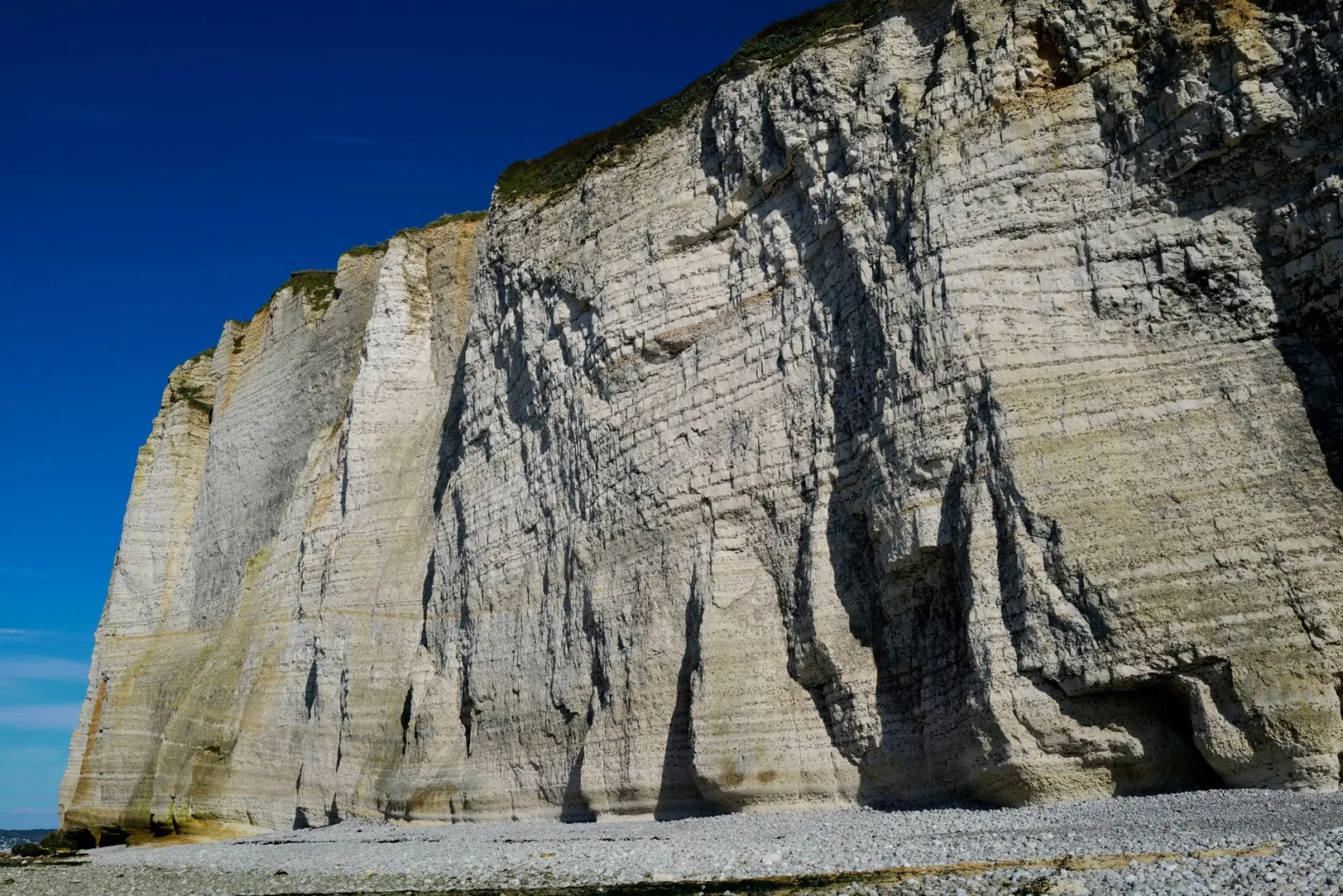 Tall white limestone sea cliffs under a blue sky